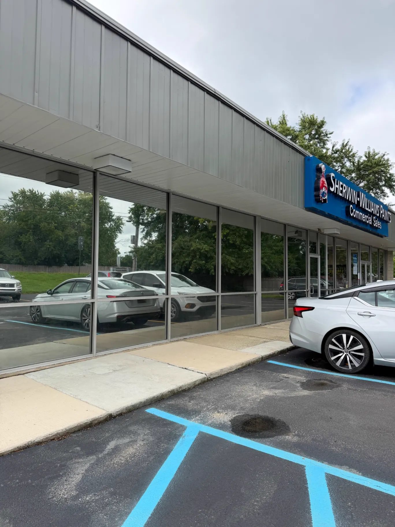 Retail storefront glazing with reflective solar control window film reflecting the parking lot in Newark, Delaware